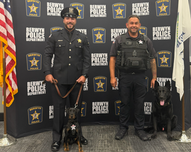 k-9 dog and officers in front of berwyn police department banner